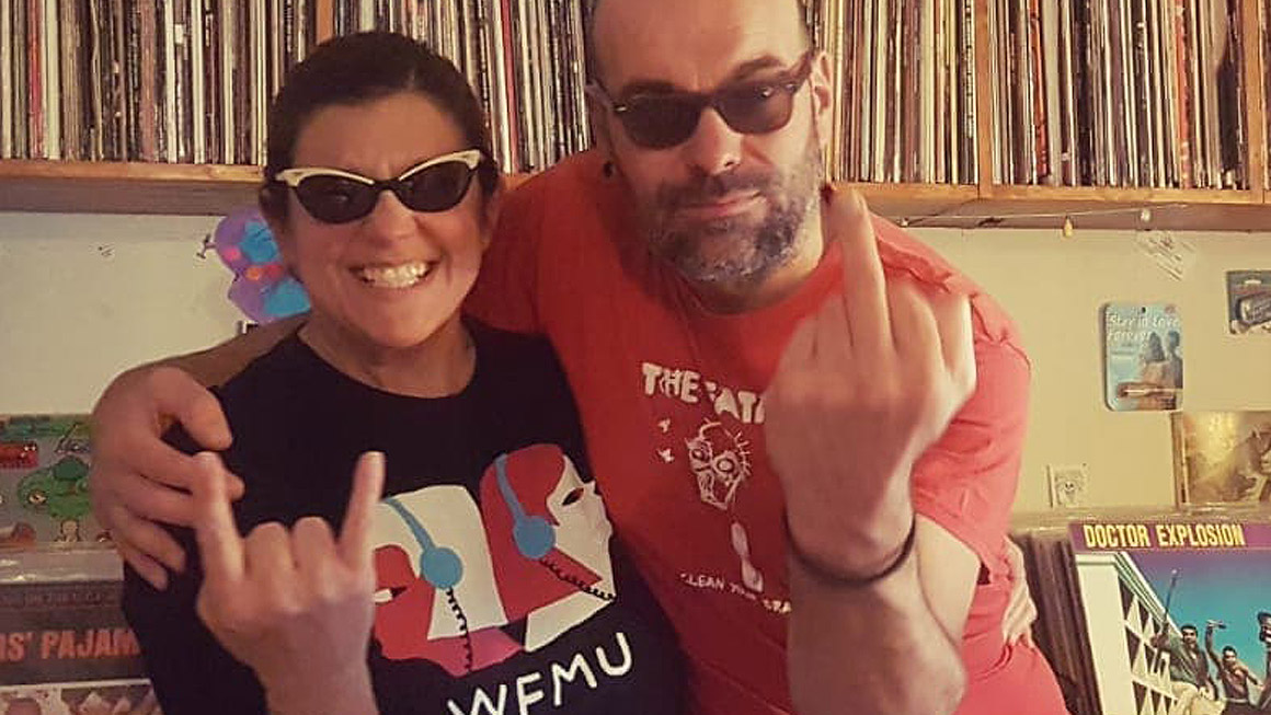 DJ Los Salvajes, Paloma and Jasper, energetically spinning vinyl with a crowd of listeners dancing in the background. Book Now Through Originaria Events.