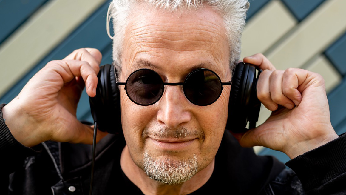 DJ Rick mixing live at a vibrant event, captivating the crowd with his eclectic blend of global beats. Book Now Through Originaria Events.